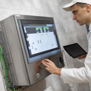 man-in-a-white-robe-and-a-cap-stands-near-the-digi-2025-02-12-22-33-32-utc